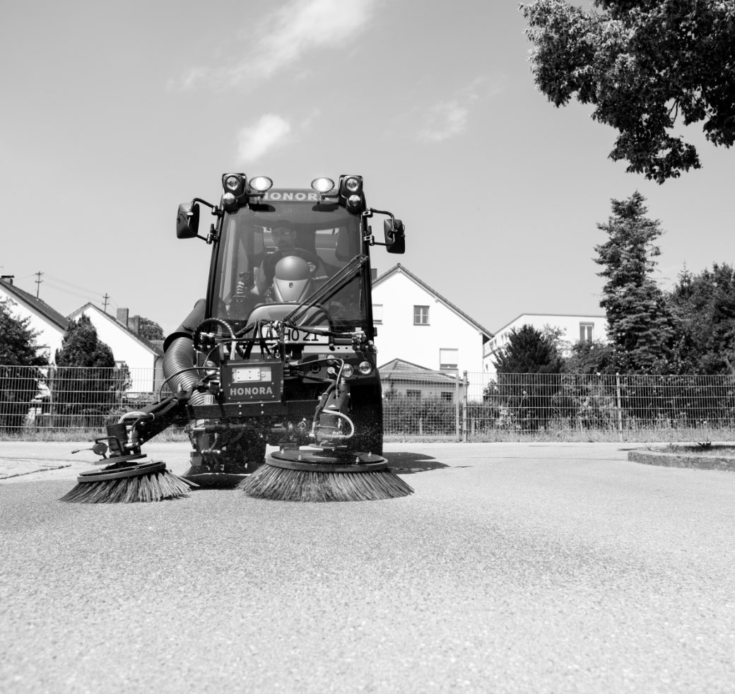 Scharzweißaufnahme einer Honora Kehrmaschine im Einsatz