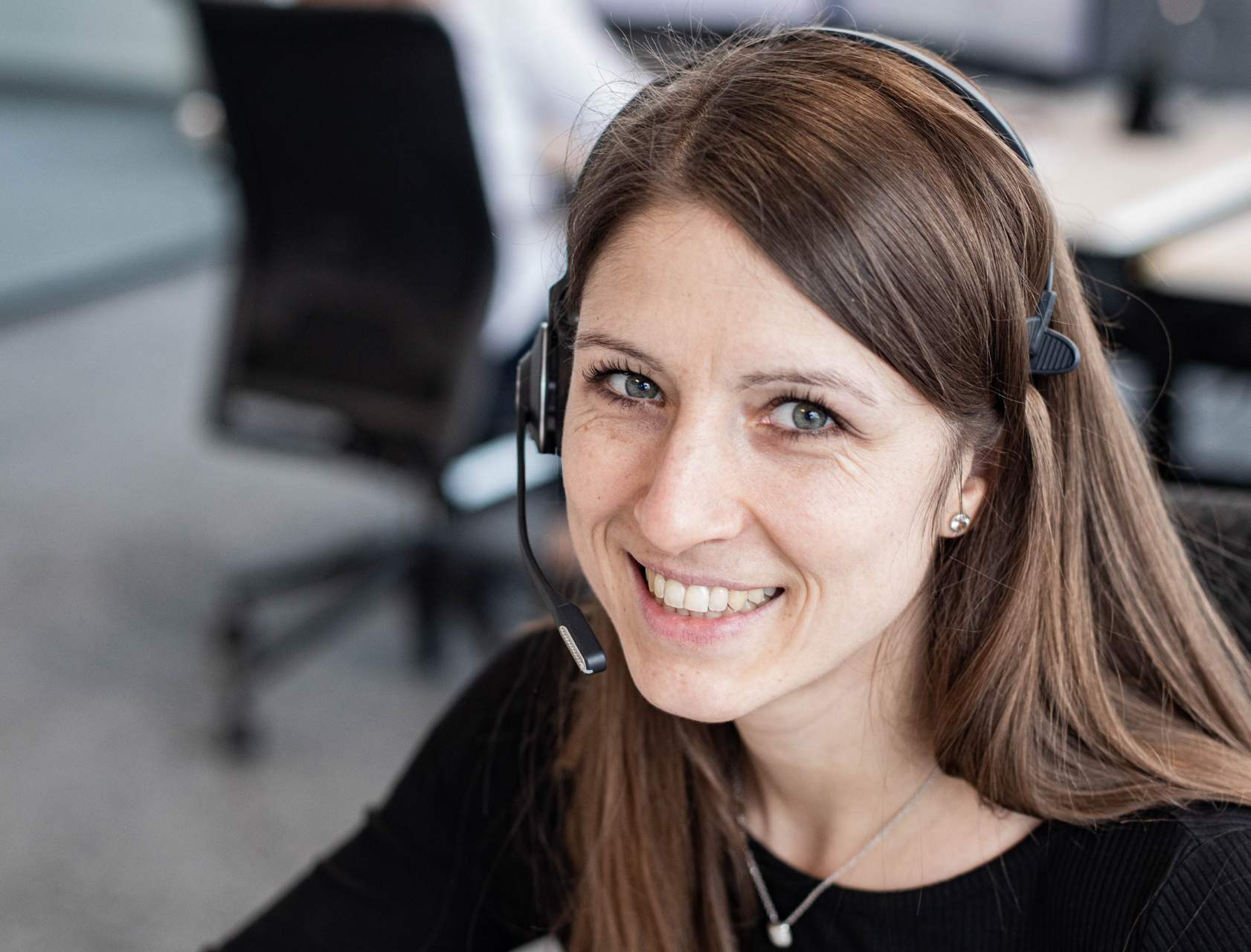 Nicole Dietrich, mit Headset an ihrem Arbeitsplatz, freut sich, Kunden weiterhelfen zu können